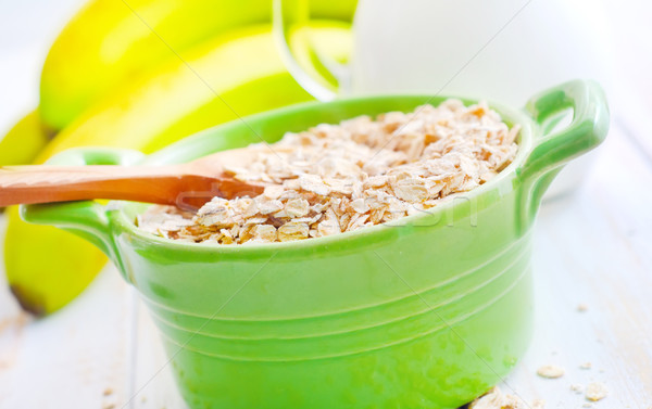 Oat flakes in the green bowl with banana and milk Stock photo © tycoon