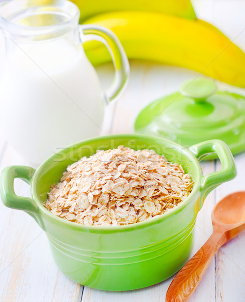 Oat flakes in the green bowl with banana and milk Stock photo © tycoon