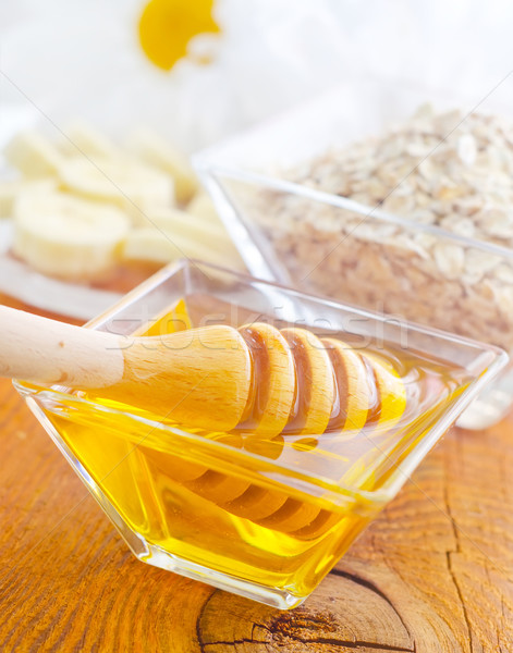 Stock photo: Honey in the glass bowl on the wooden table