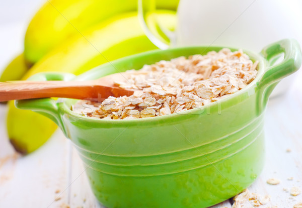 Oat flakes in the green bowl with banana and milk Stock photo © tycoon
