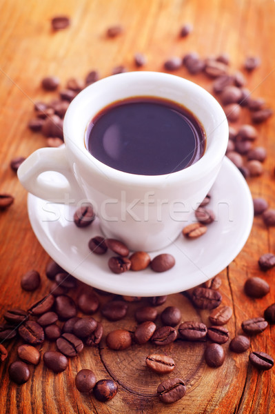 fresh coffee in the white cup, coffee beans on wooden background Stock photo © tycoon