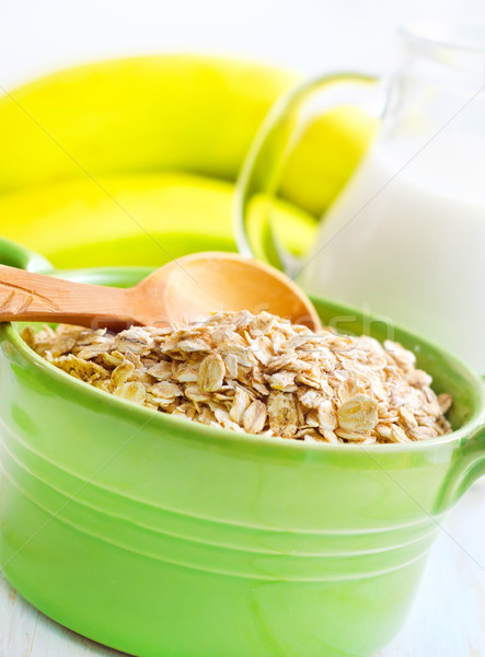 Oat flakes in the green bowl with banana and milk Stock photo © tycoon