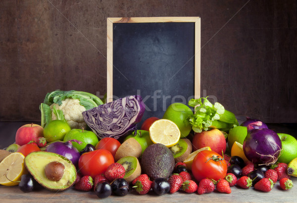 Stock photo: Fruits and vegetables around empty chalkboard