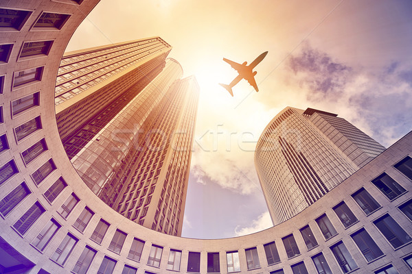 plane flying over modern office towers Stock photo © unkreatives