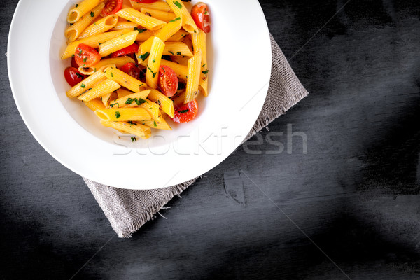 Penne with anchovy and tomato in a white plate. Stock photo © user_11224430