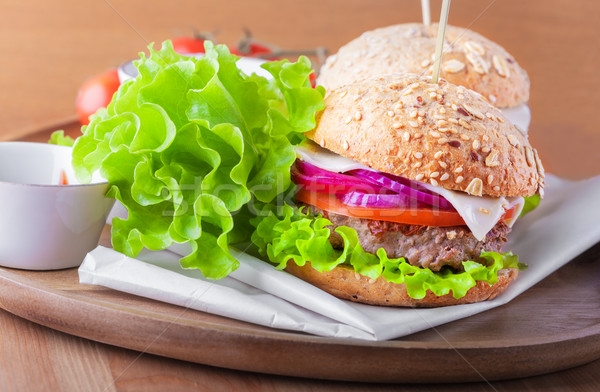 Stock photo: Cheeseburger with salad, onion tomato and fresh bread.