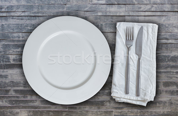 Empty plate with cutlery on stone texture background Stock photo © user_9870494