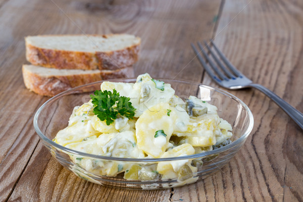 Potato salad in a glass bowl on wooden board Stock photo © user_9870494