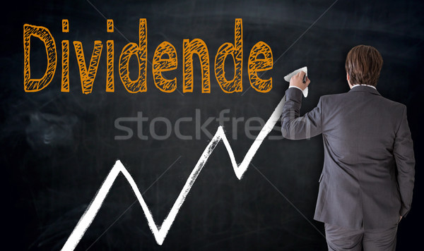 Businessman writes Dividende (in german dividend) on blackboard  Stock photo © user_9870494