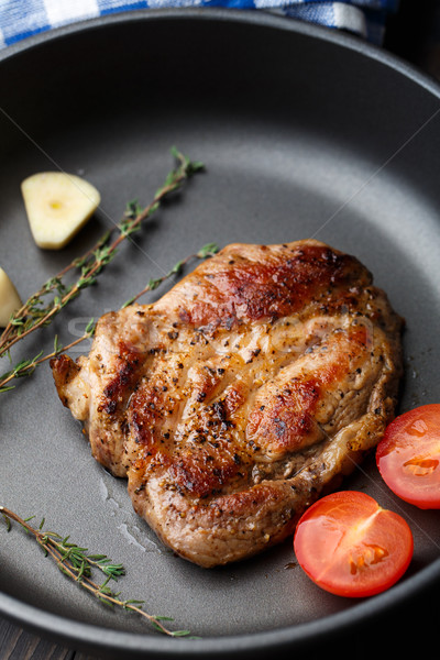 Steak with thyme, tomato and garlic. Stock photo © vankad