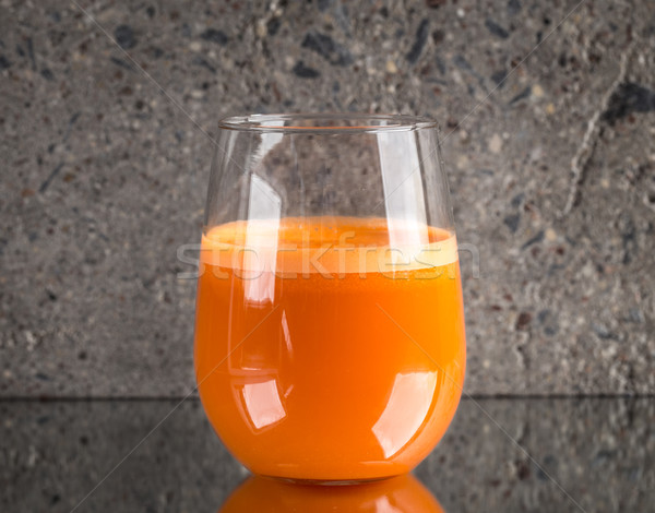 Glass of fresh carrot juice on concrete background Stock photo © vankad