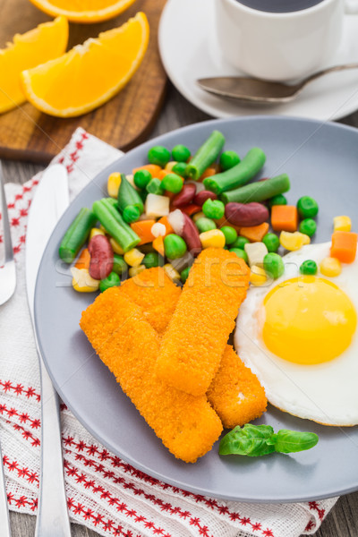 Fish sticks, fried egg and vegetables Stock photo © vankad