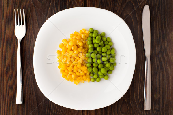 Heap of corn seeds and peas on plate Stock photo © vankad