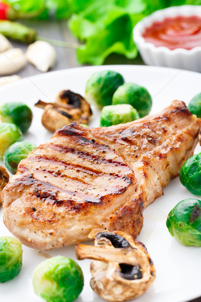Grilled pork chop with brussels sprouts Stock photo © vankad