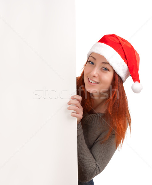 Woman in santa hat peeking out of blank poster Stock photo © vankad