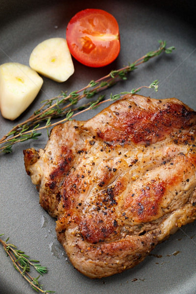 Steak with thyme, tomato and garlic. Stock photo © vankad