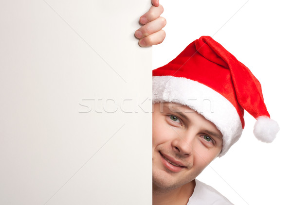 Man with santa hat peeking out of blank poster Stock photo © vankad