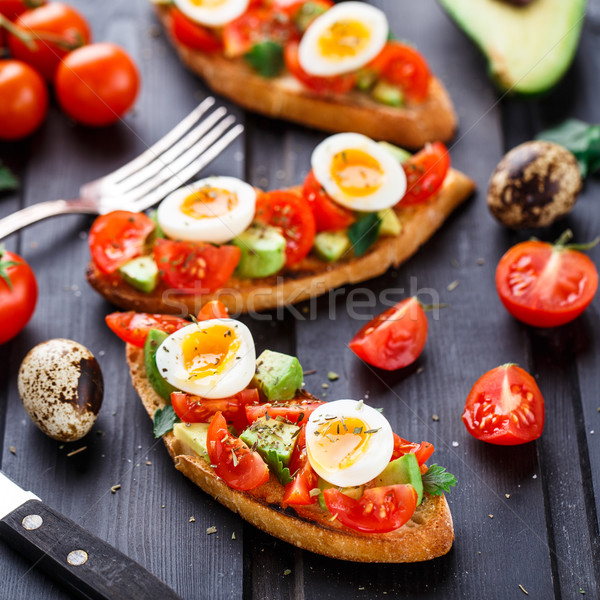 Bruschetta pomodoro avocado uovo tavolo in legno rosso Foto d'archivio © vankad