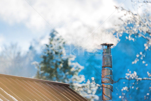 Smoke from the chimney on the roof Stock photo © vapi