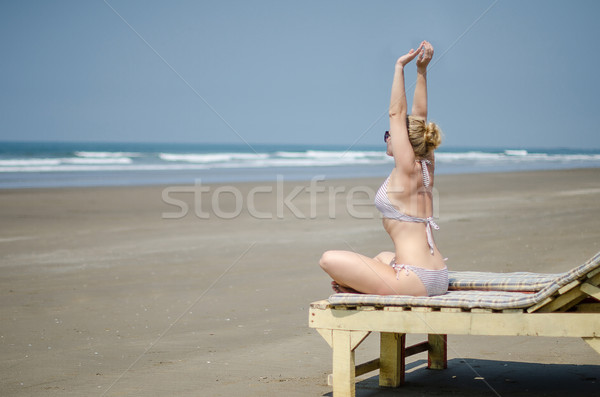blonde girl in bikini doing yoga on a sun lounger on the ocean Stock photo © vasilixa