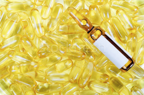 Golden pills and yellow ampoule Stock photo © vavlt