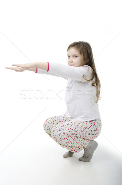 Little girl in nightwear warm-up on white Stock photo © velkol
