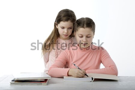 Little girls read books at the table on white Stock photo © velkol