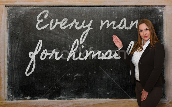 Stock photo: Teacher showing Every man for himself on blackboard