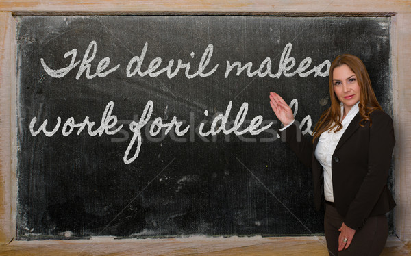 Teacher showing The devil makes work for idle hands on blackboar Stock photo © vepar5