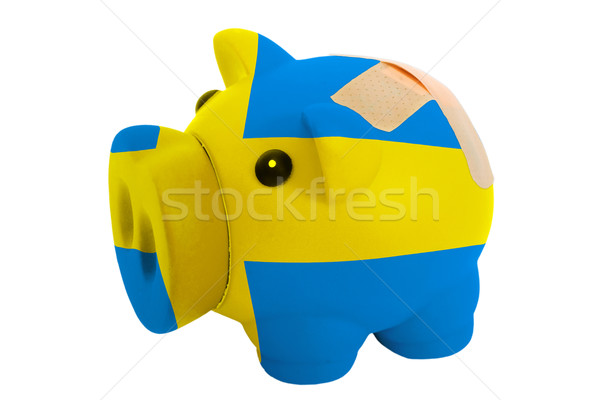 closed piggy rich bank with bandage in colors national flag of s Stock photo © vepar5