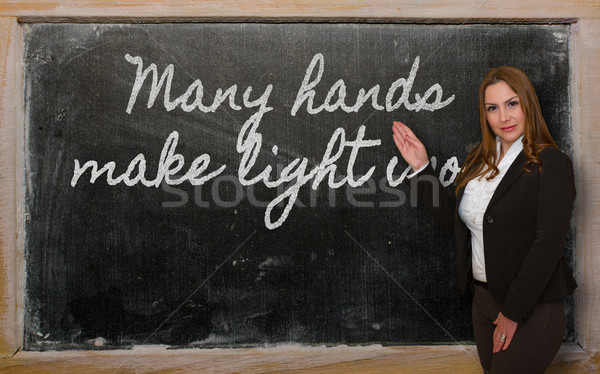 Stock photo: Teacher showing Many hands make light work on blackboard