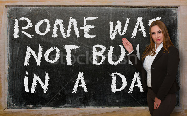Teacher showing Rome was not built in a day on blackboard Stock photo © vepar5