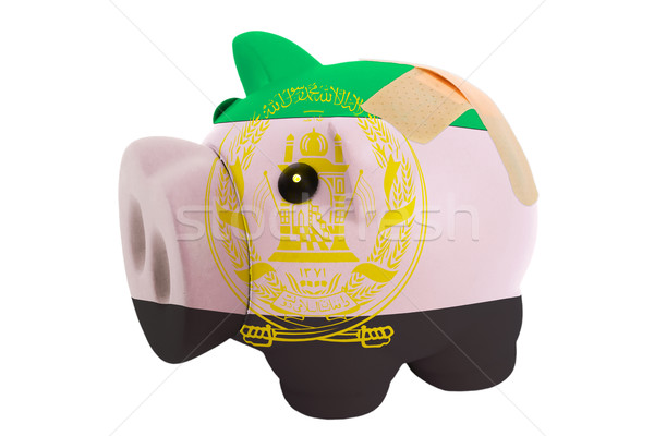 closed piggy rich bank with bandage in colors national flag of a Stock photo © vepar5