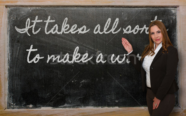 Teacher showing It takes all sorts to make a world on blackboard Stock photo © vepar5