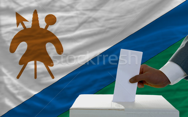 man voting on elections in front of national flag of lesotho Stock photo © vepar5