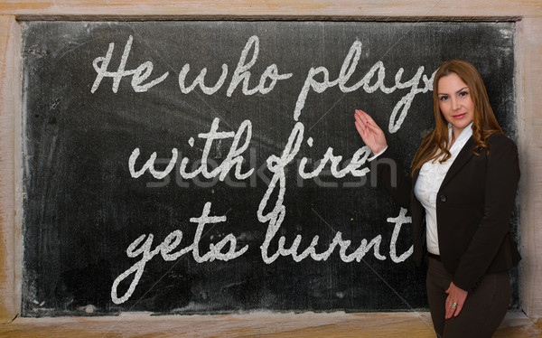 Teacher showing He who plays with fire gets burnt on blackboard Stock photo © vepar5