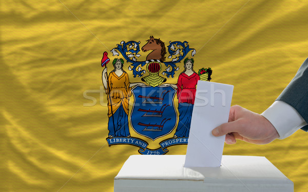 man voting on elections in front of flag US state flag of new je Stock photo © vepar5