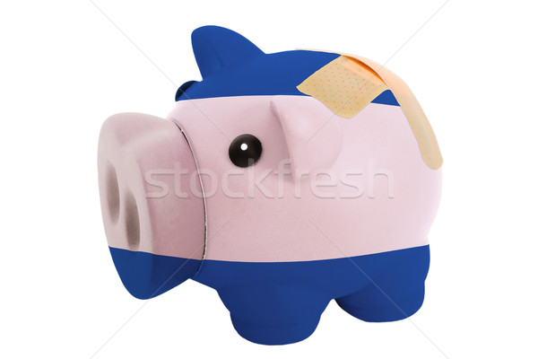 closed piggy rich bank with bandage in colors national flag of n Stock photo © vepar5