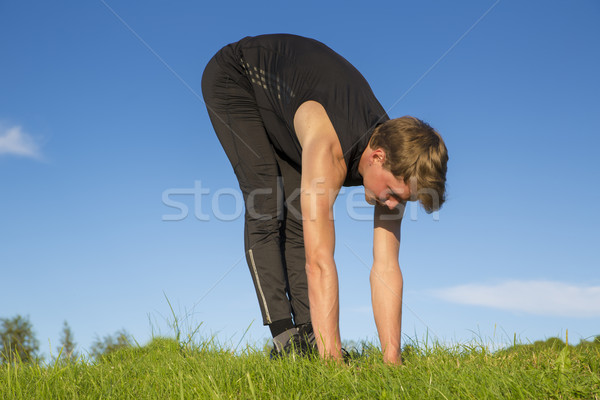 Sportsman making exercise movements to stretch muscles Stock photo © vetdoctor