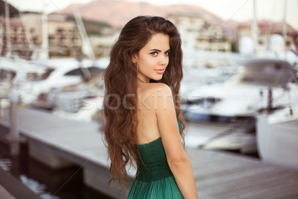 Beautiful young smiling girl with long hair by the yacht at suns Stock photo © Victoria_Andreas