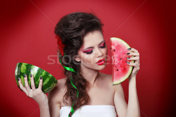 Young beauty woman holding watermelon in her hand over red backg Stock photo © Victoria_Andreas