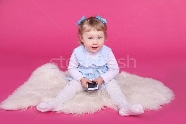 Funny little girl playing with mobile phone over pink background Stock photo © Victoria_Andreas