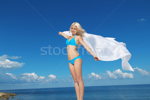 Beautiful young woman with blowing tissue and delight at the blu Stock photo © Victoria_Andreas