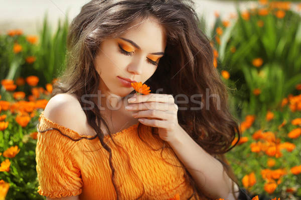 Beautiful Teenage Model girl smelling flower, over marigold flow Stock photo © Victoria_Andreas