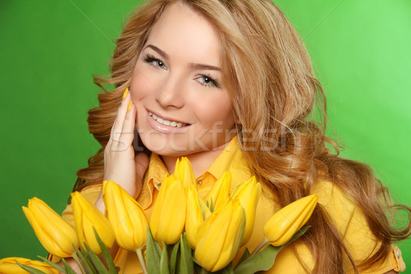 Happy smiling girl with spring-flowering yellow tulips isolated  Stock photo © Victoria_Andreas