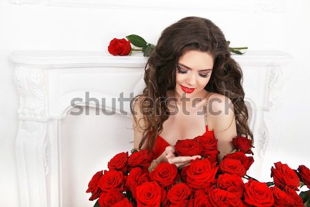 Beautiful brunette woman with red roses flowers bouquet in moder Stock photo © Victoria_Andreas