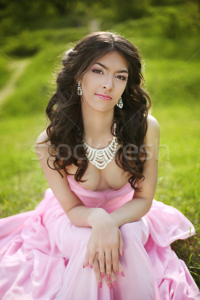 Brunette bride in pink wedding dress resting and sitting on gree Stock photo © Victoria_Andreas