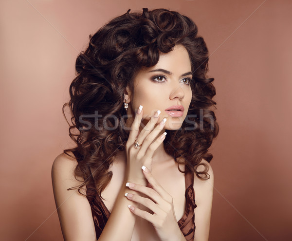 Beautiful girl with long curly hair. Makeup. Manicured nails. Br Stock photo © Victoria_Andreas