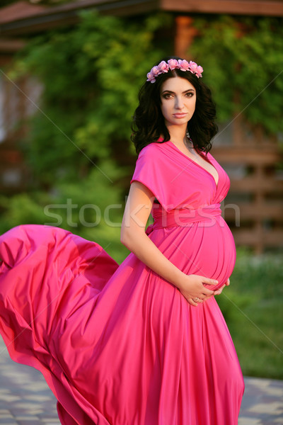 Beautiful pregnant woman touching her belly wearing in pink dres Stock photo © Victoria_Andreas