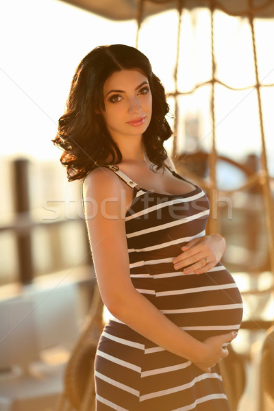Beautiful pregnant woman touching her belly against rope border  Stock photo © Victoria_Andreas